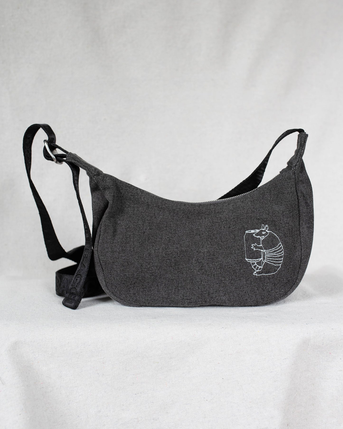 Gray shoulder bag with an armadillo on a light gray background