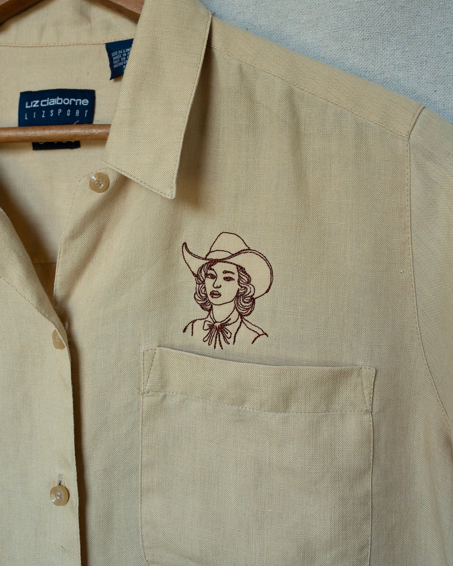 detail of cowgirl embroidery on pale yellow shirt