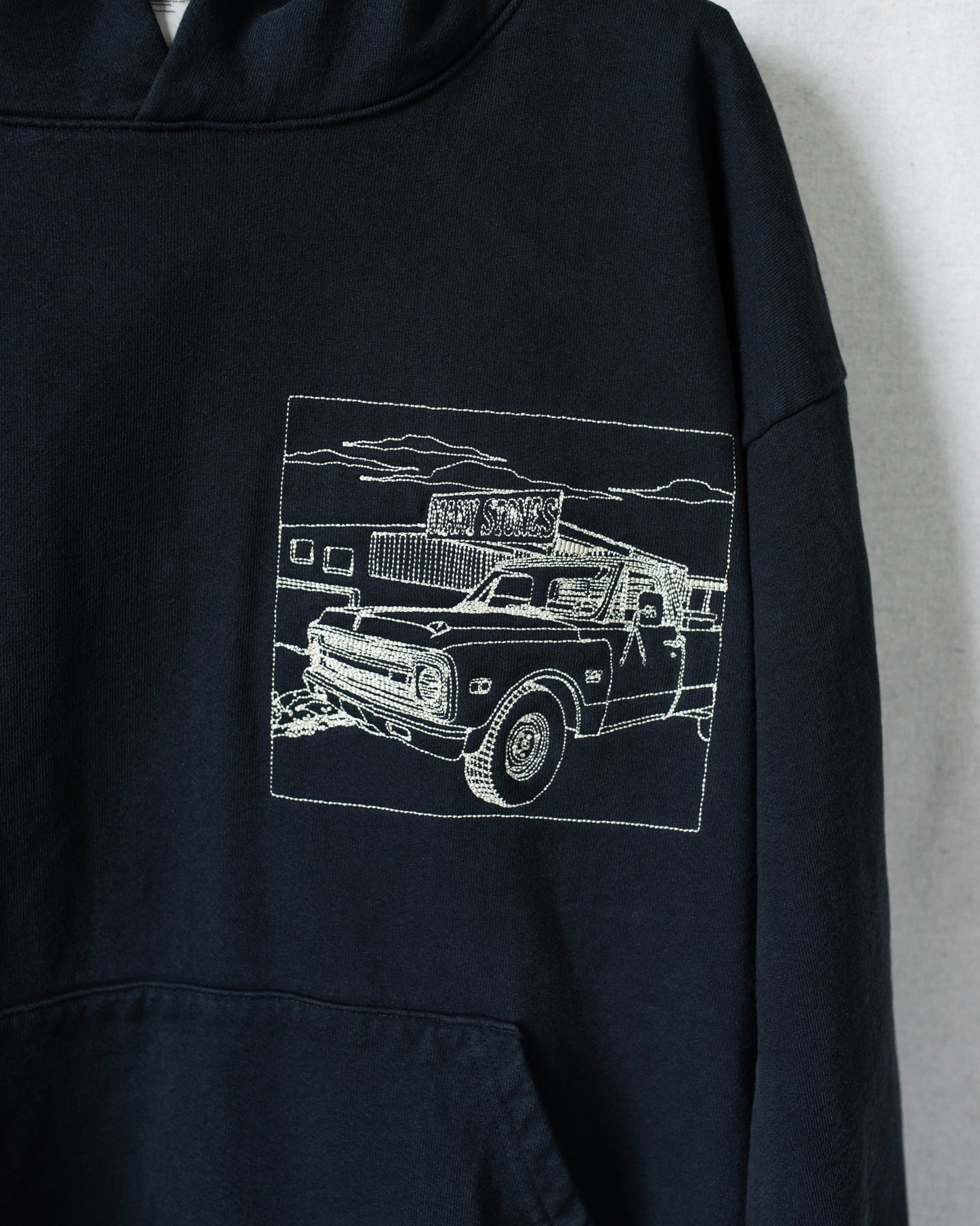 Detailed shot of embroidered truck on front chest area.