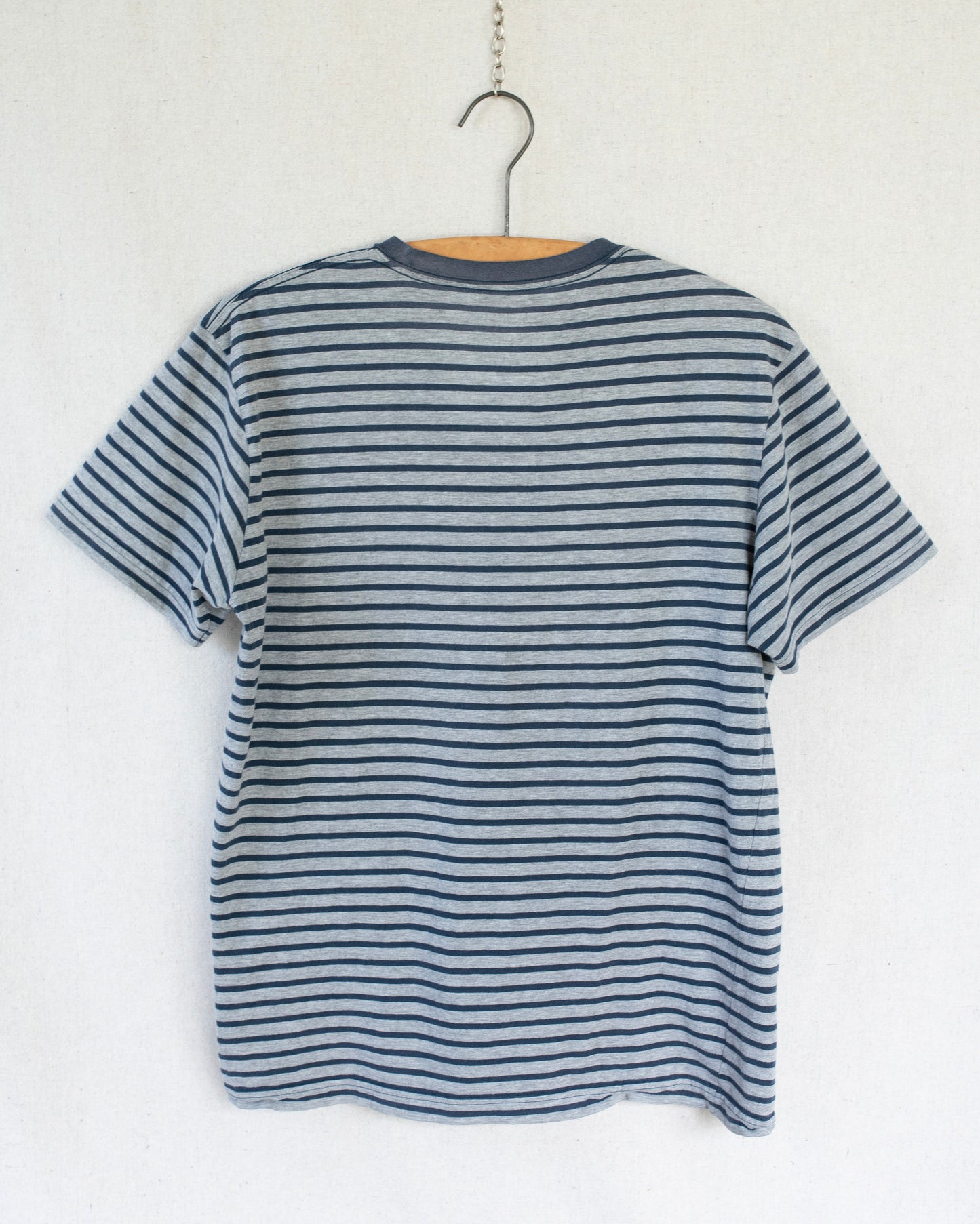 Striped t-shirt on a hanger against a white background