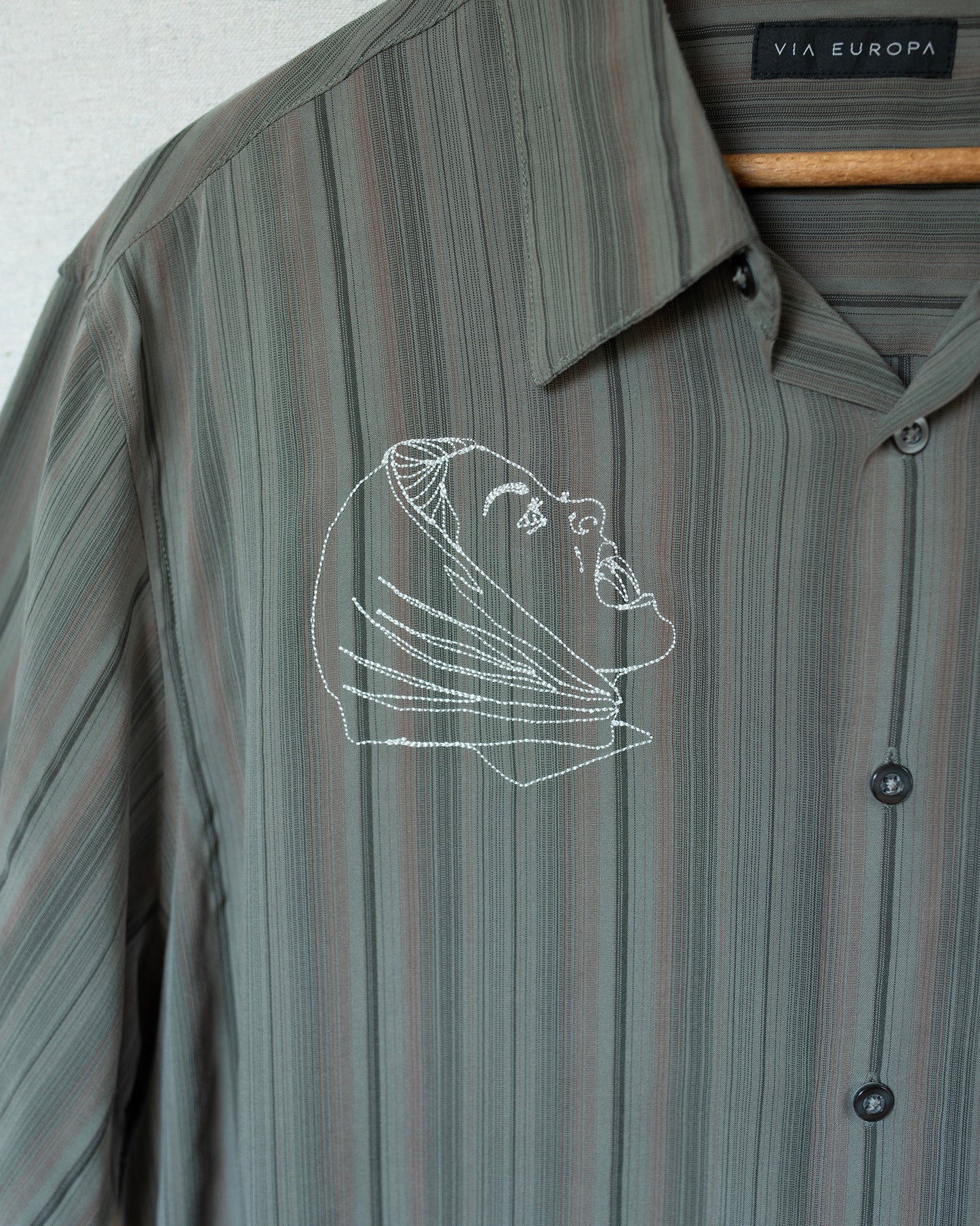 Striped shirt with embroidered design on a white background