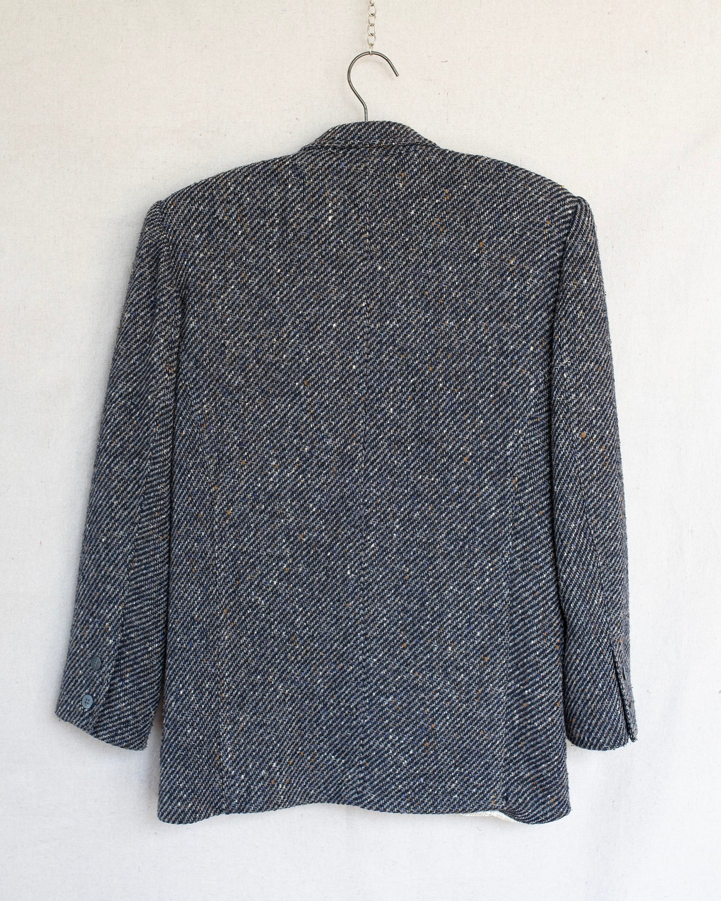 Gray textured blazer on a hanger against a white background