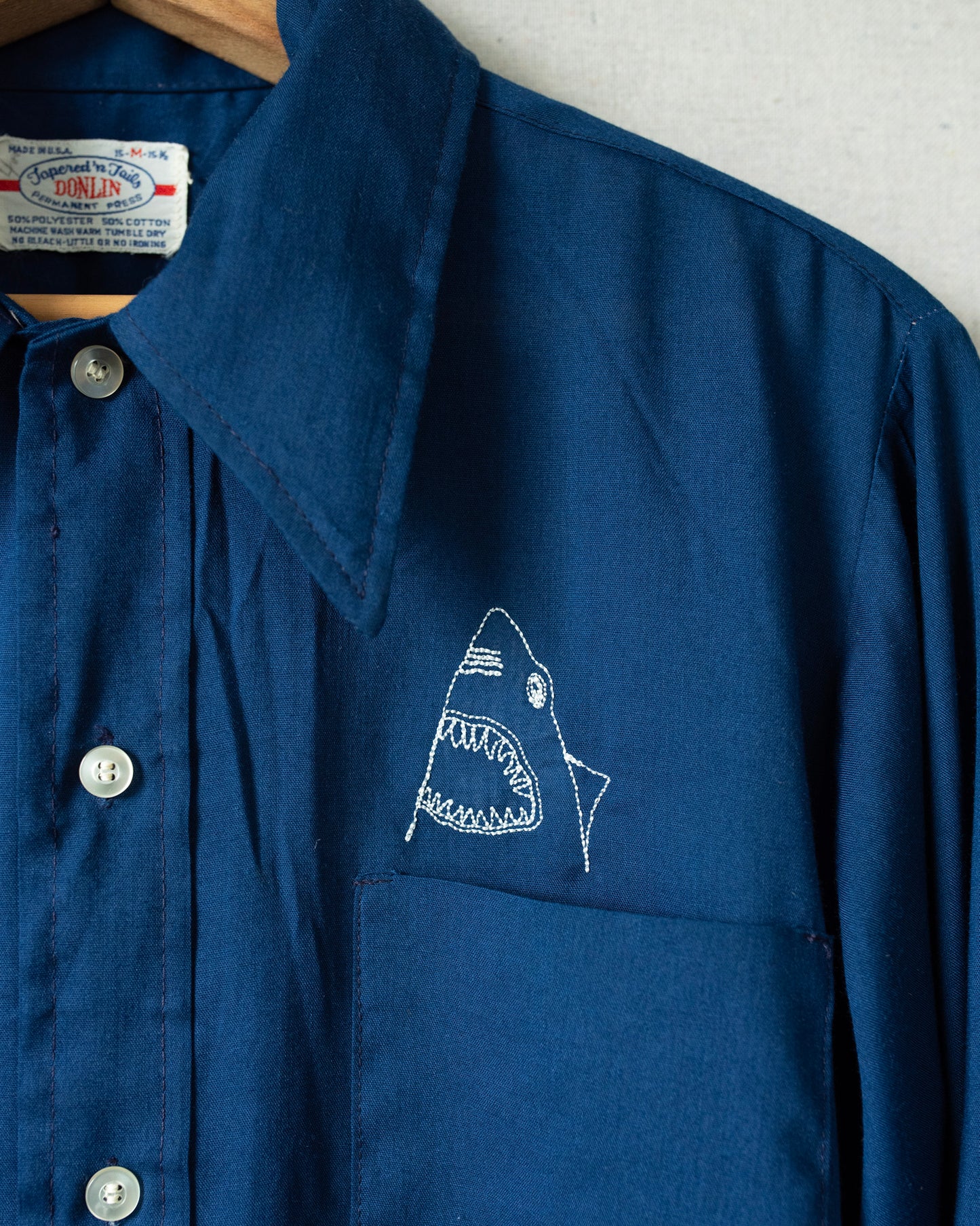 Detailed shot of shark embroidery over chest pocket.