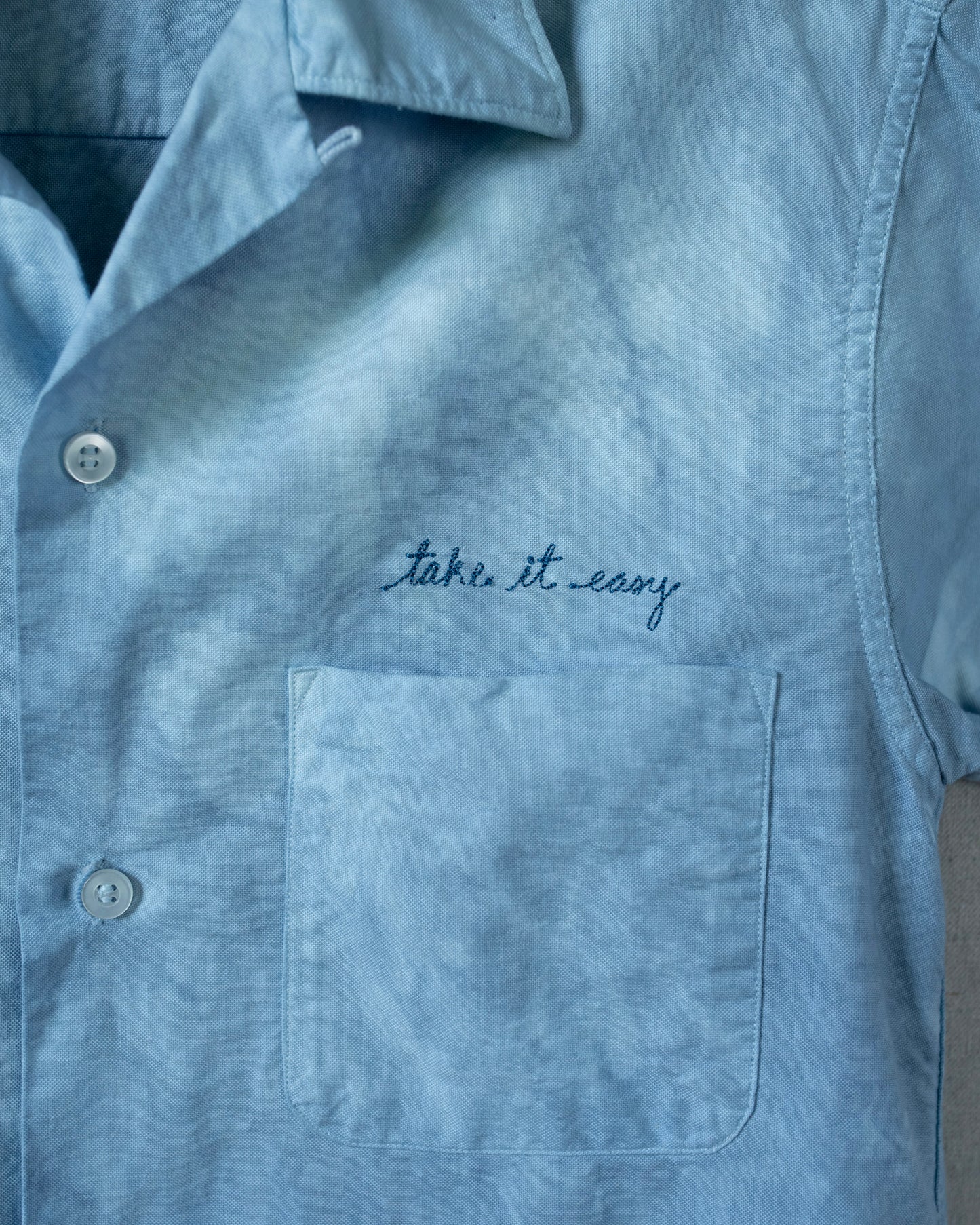 Light blue shirt with 'take it easy' embroidery above a pocket
