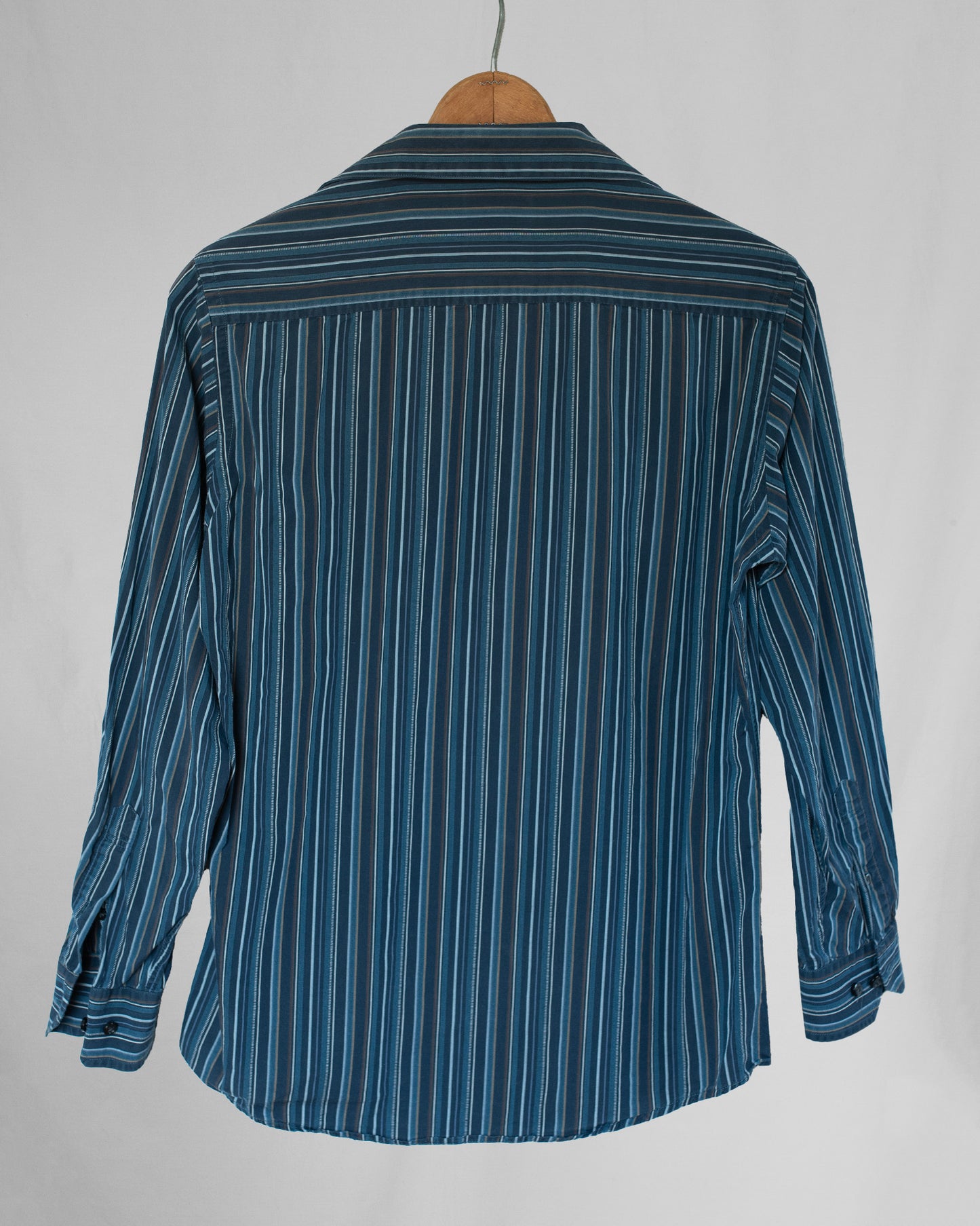 Blue striped shirt on a hanger against a gray background