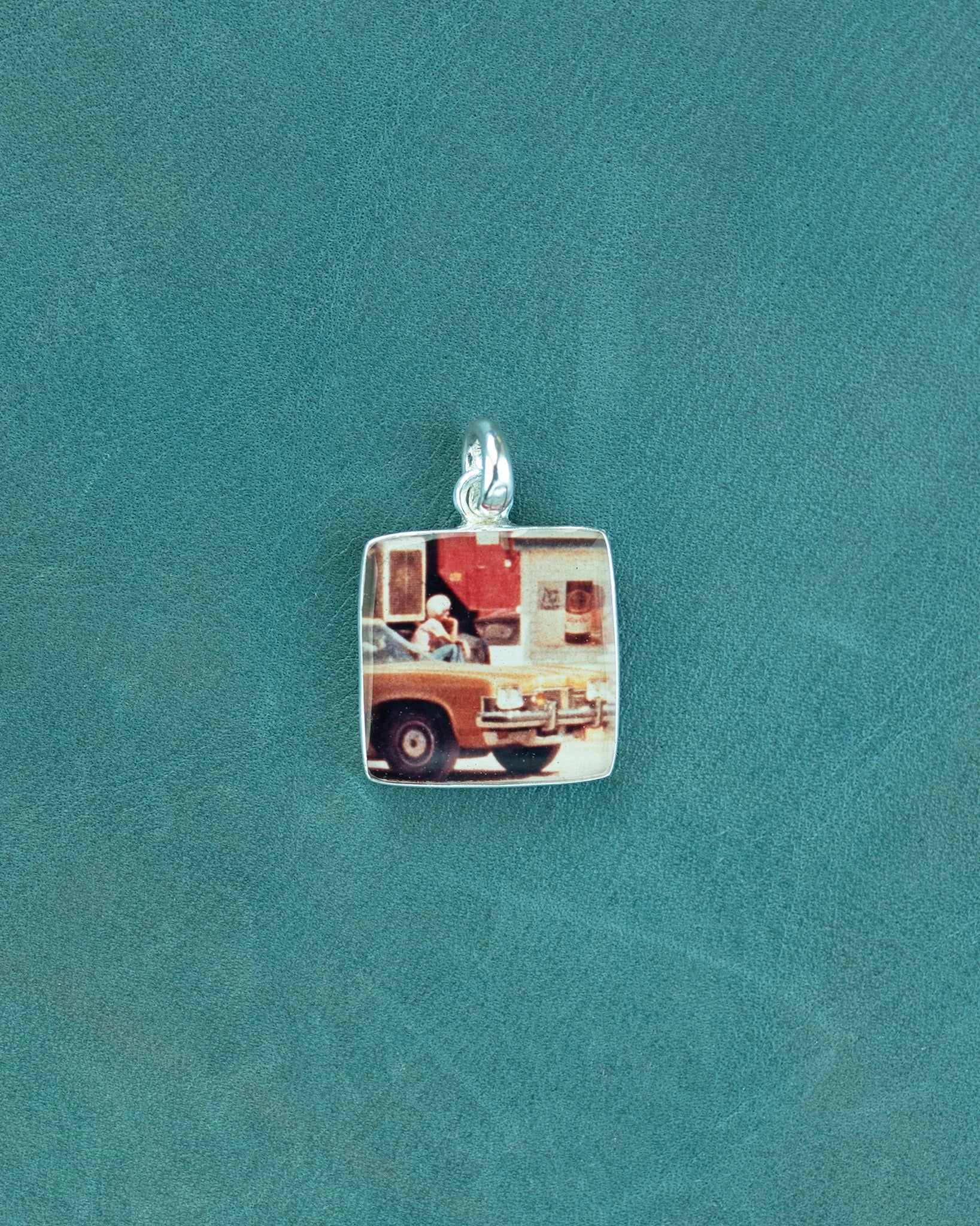 Small square charm with car image.