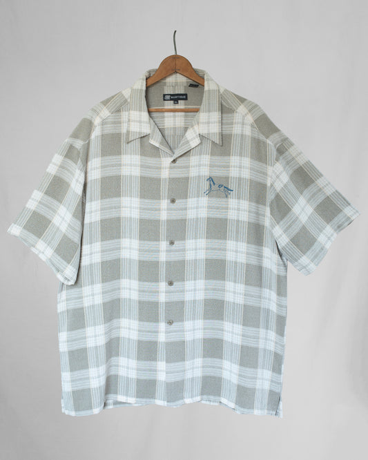 Plaid shirt with horse embroidery on a hanger against a plain background