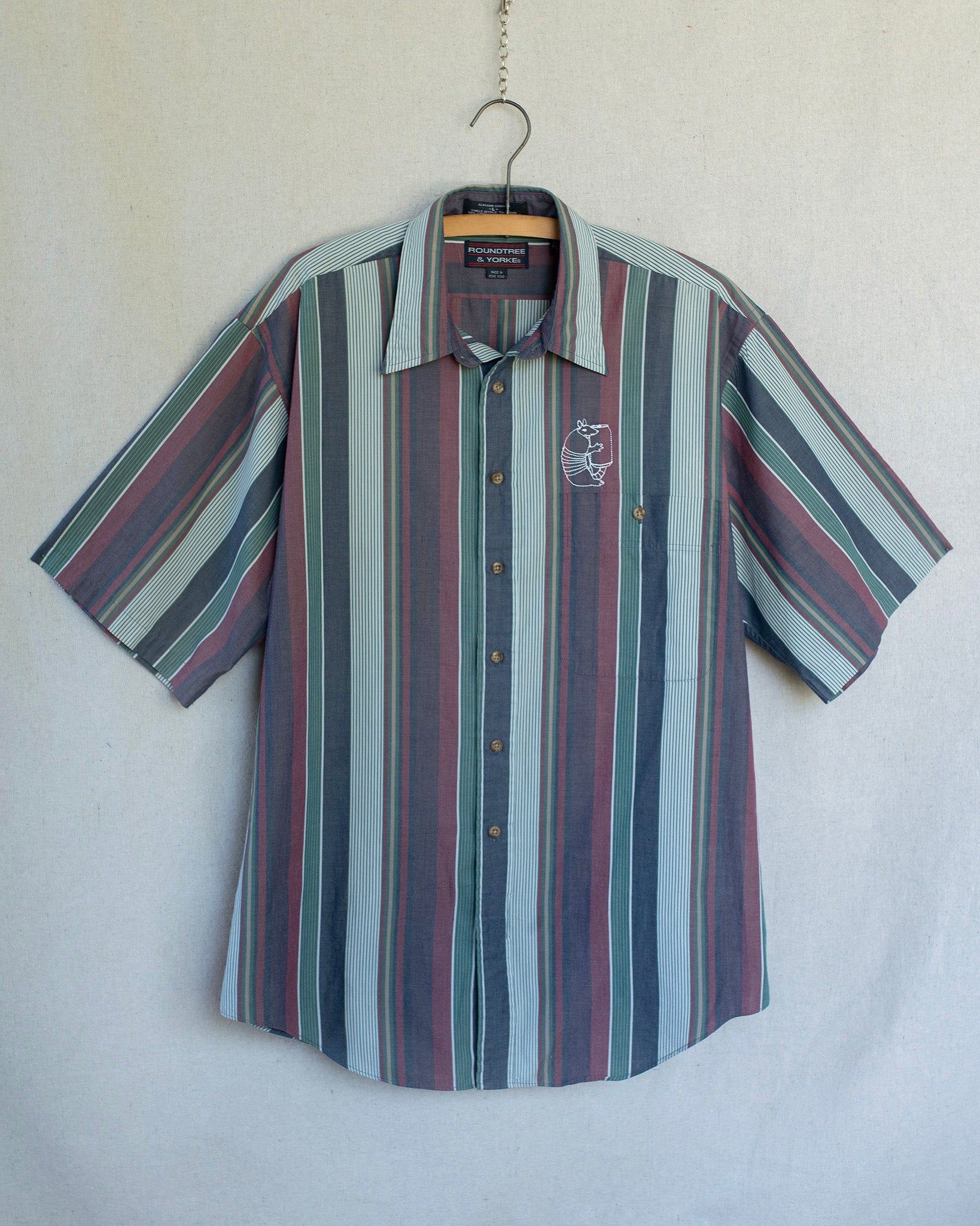 Striped shirt on a hanger against a plain background