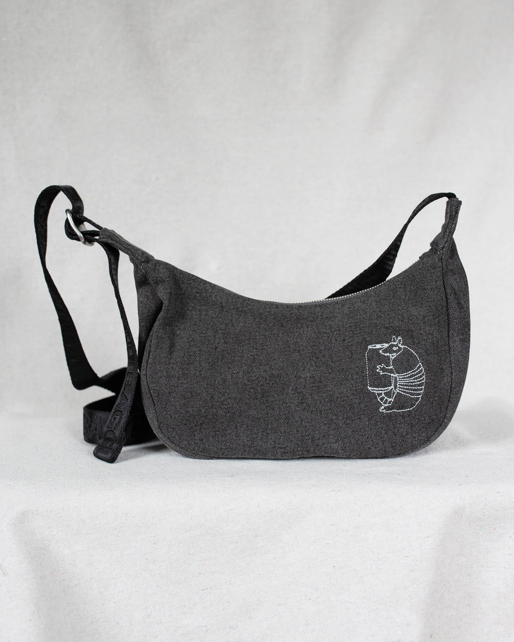 Gray shoulder bag with an armadillo on a light gray background