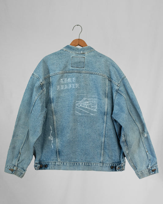 1990s Levis denim jacket with embroidery and a boxy fit, displayed on a hanger against a white background.