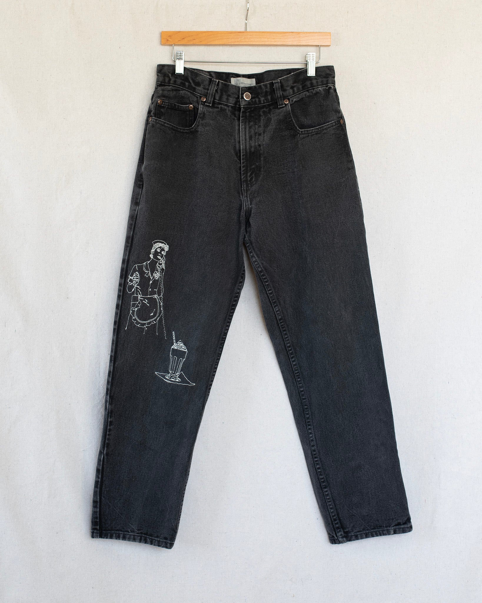 Black jeans with embroideries on a light gray background
