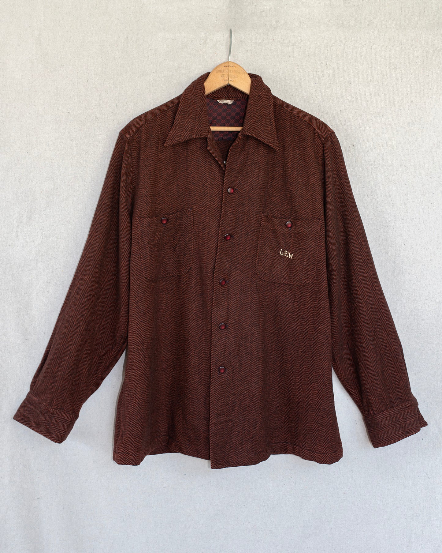 Brown shirt on a hanger against a white background