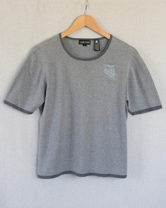 Gray t-shirt with embroidery on a hanger against a white background