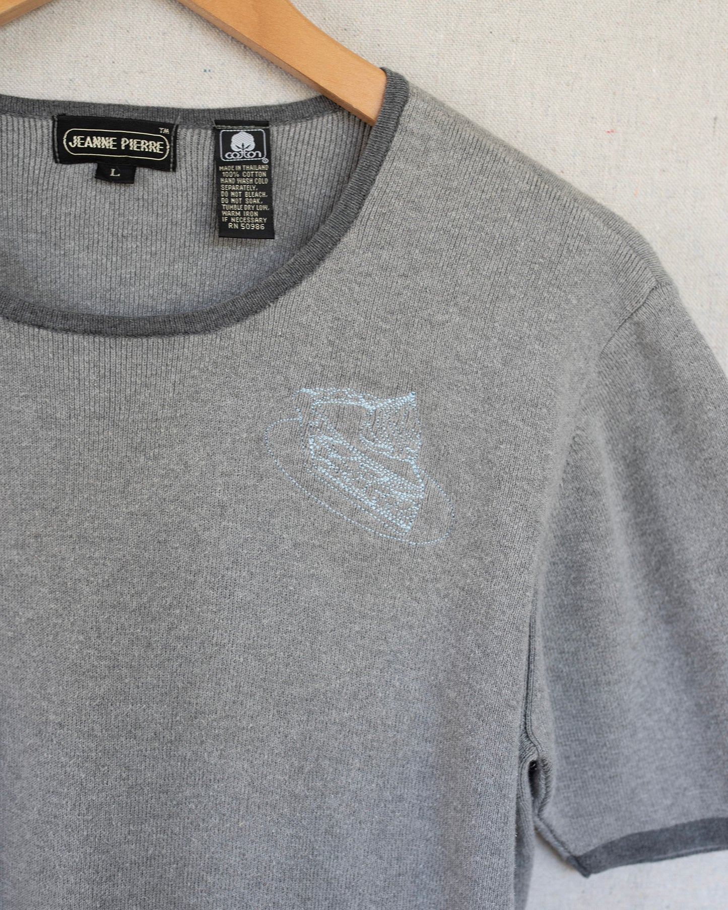 Gray t-shirt with embroidery close up on a white background