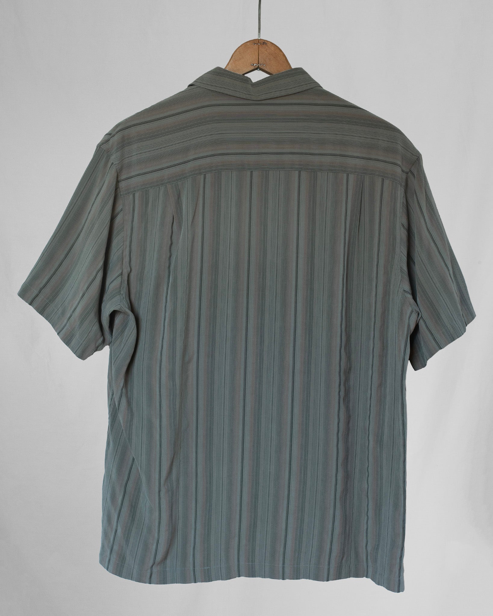 Striped shirt on a hanger against a white background