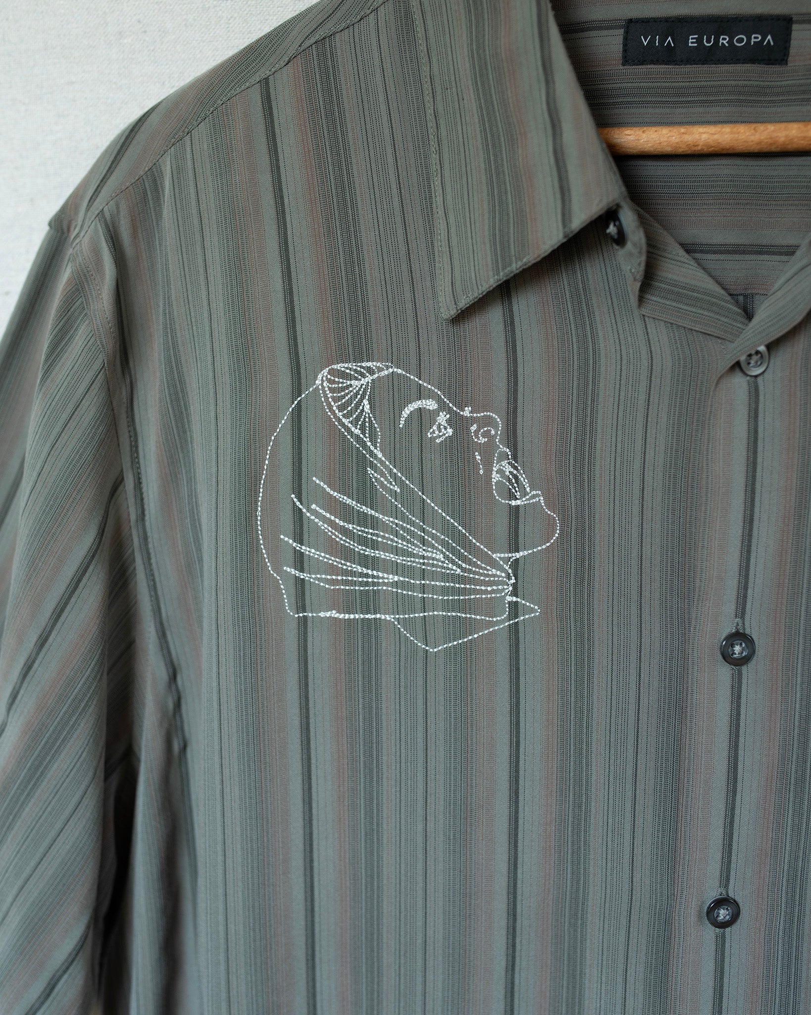 Striped shirt with embroidered design on a white background