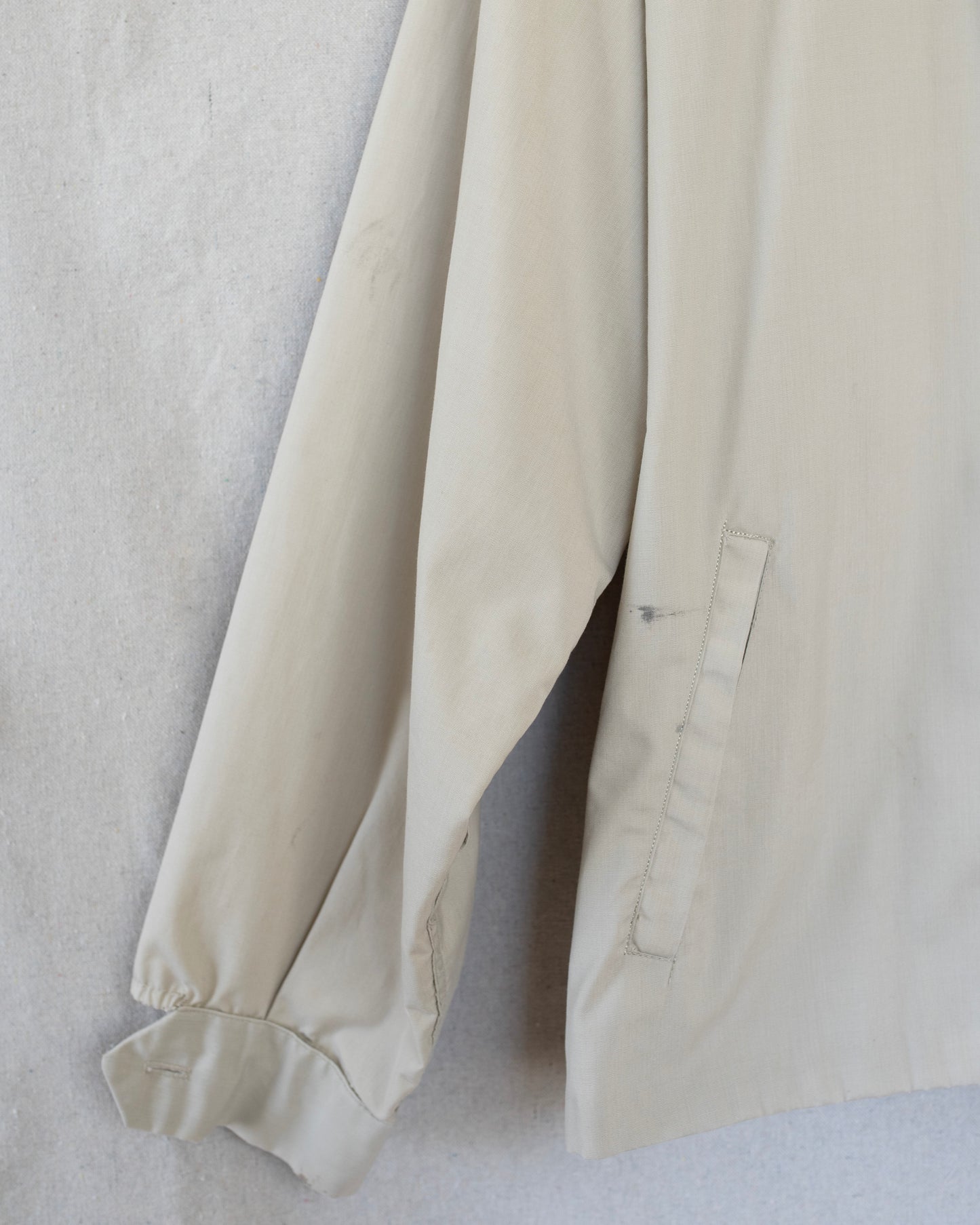 Close-up of a beige fabric garment on a light gray background