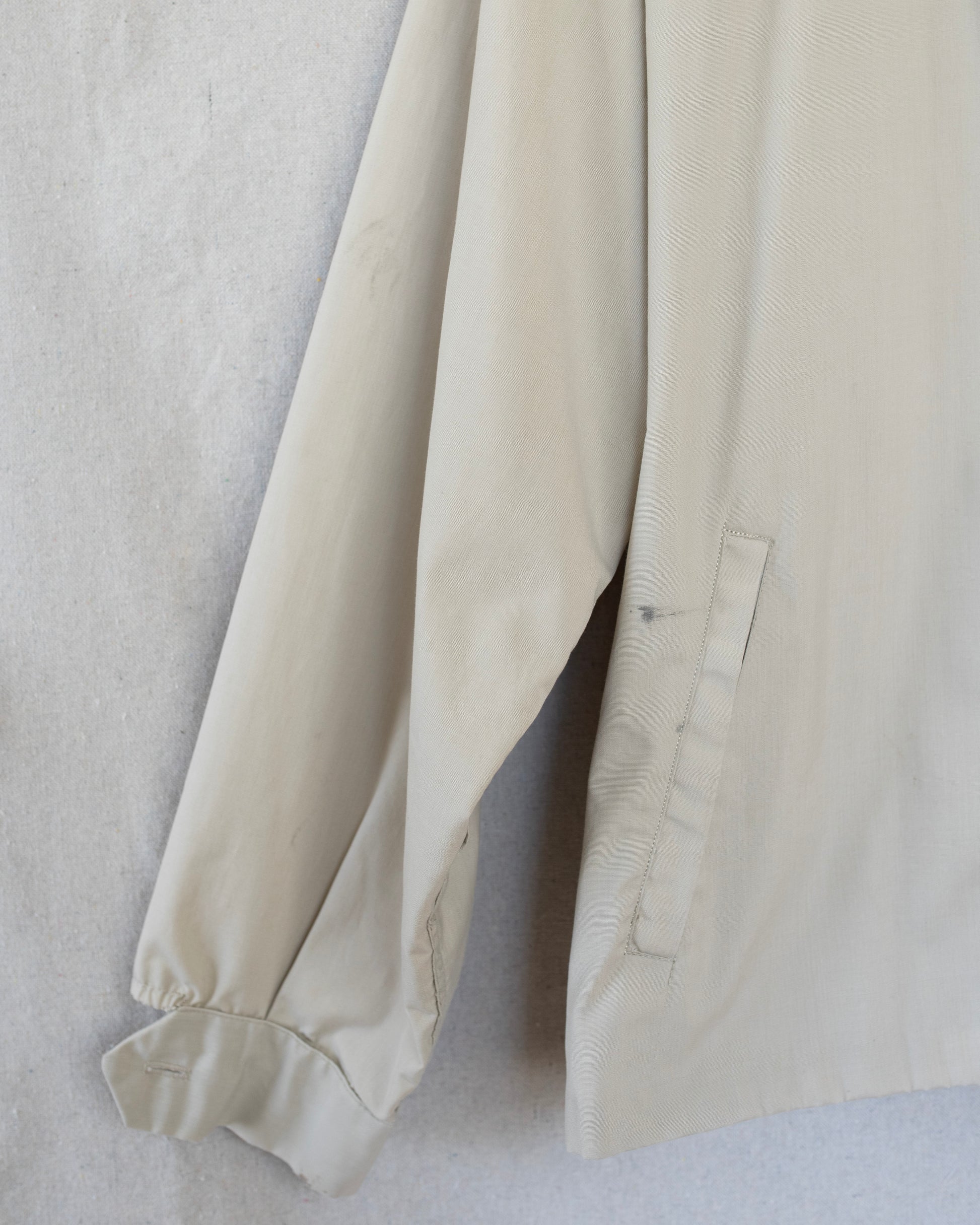 Close-up of a beige fabric garment on a light gray background