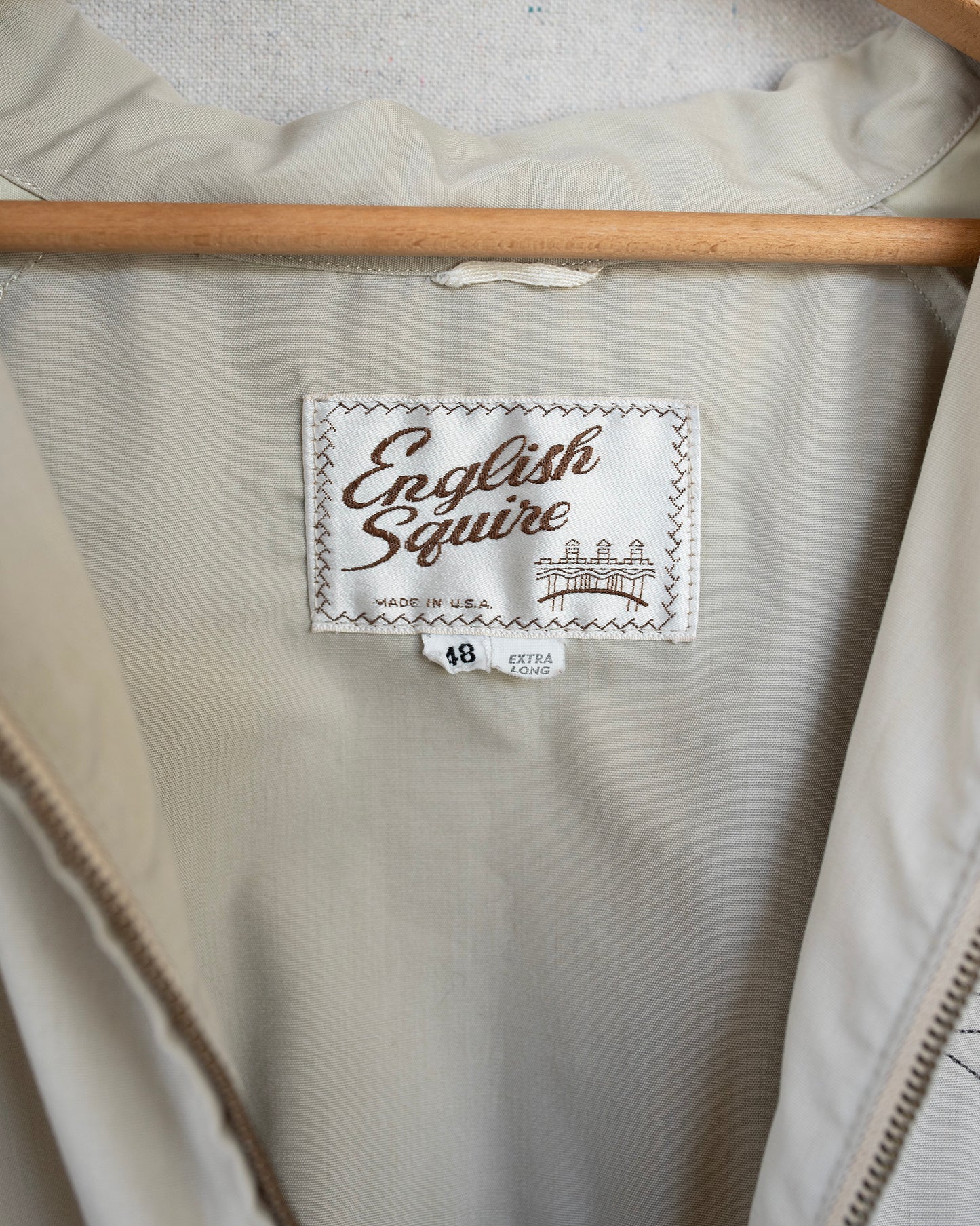 Beige jacket with 'English Squire' label on a hanger