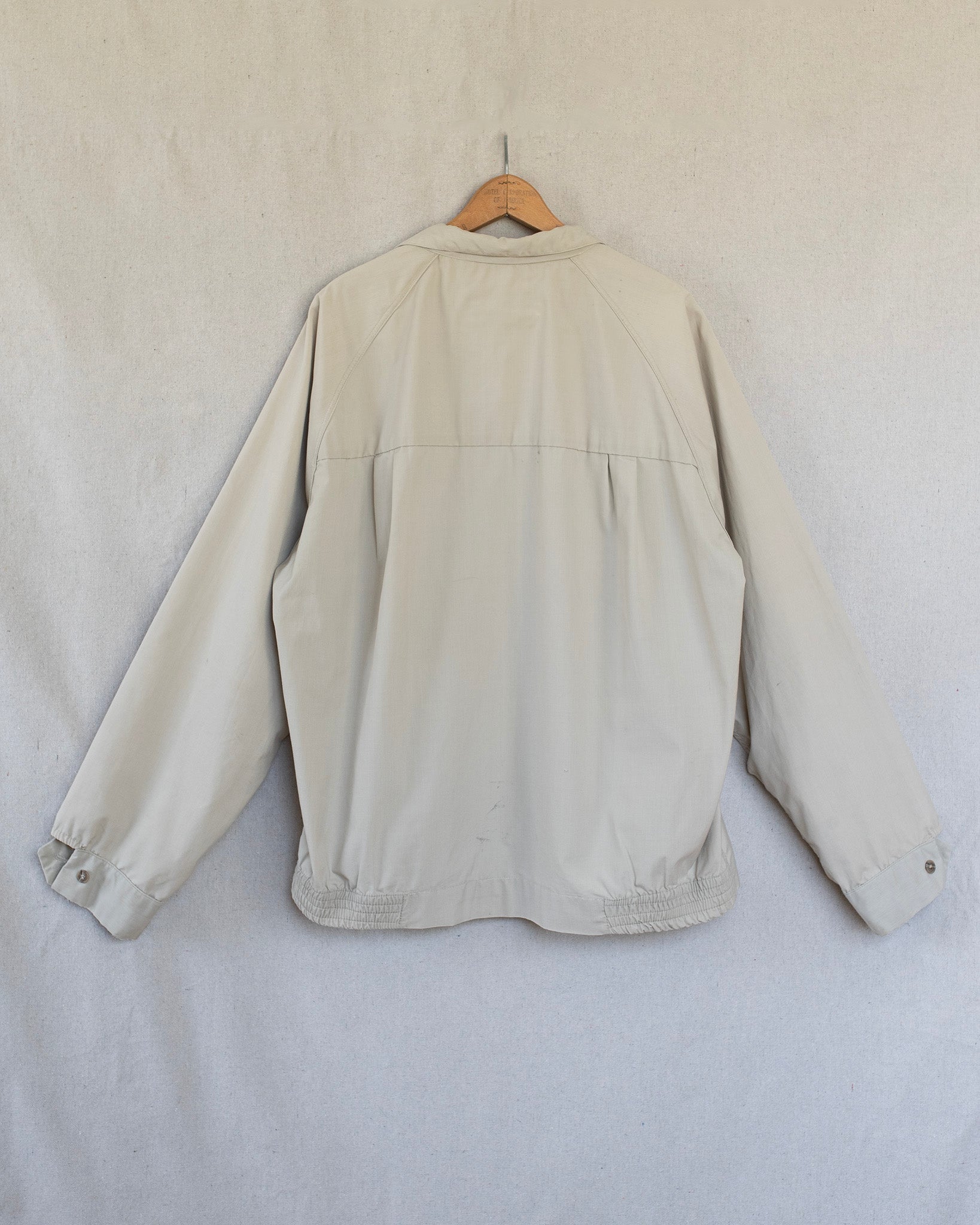 Beige jacket on a hanger against a white background