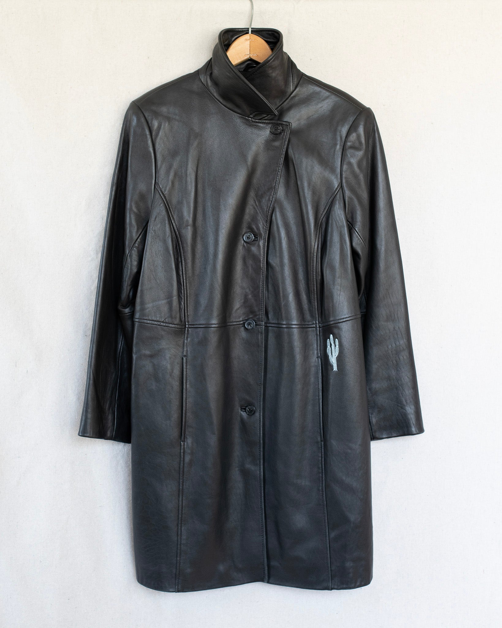 Black leather coat on a hanger against a white background