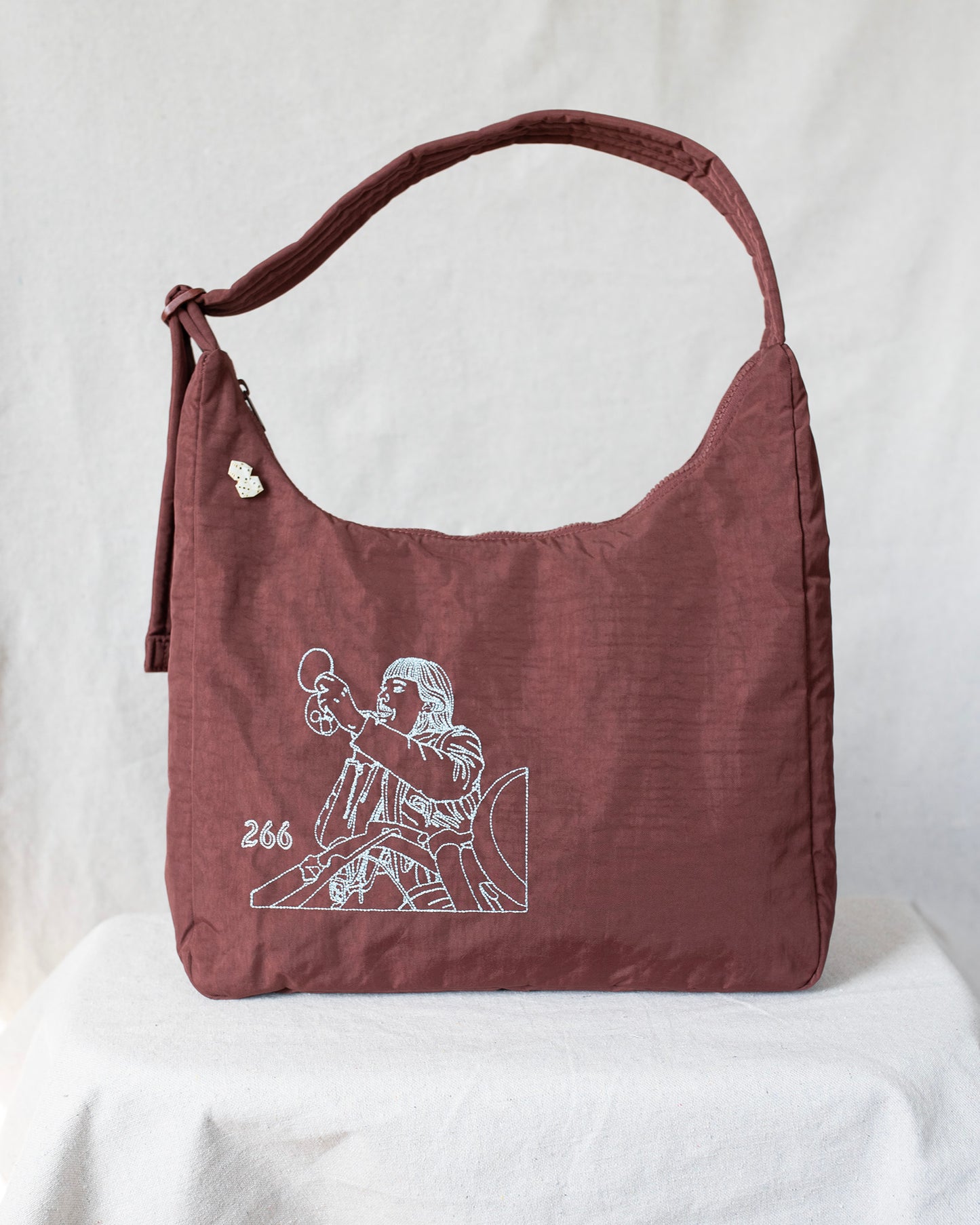 Mahogany shoulder bag with embroideries on a white background
