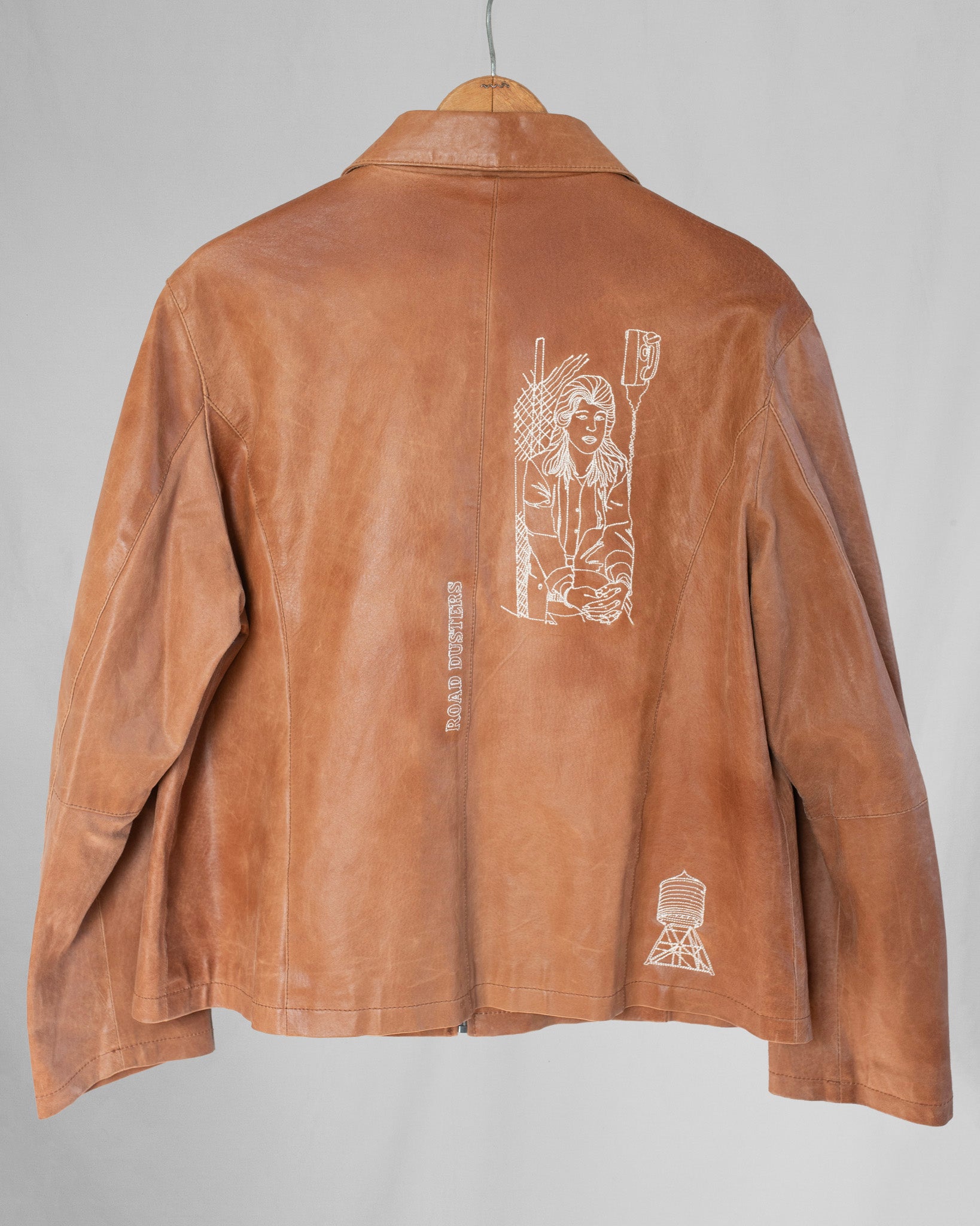 Brown jacket with white embroideries on a gray background