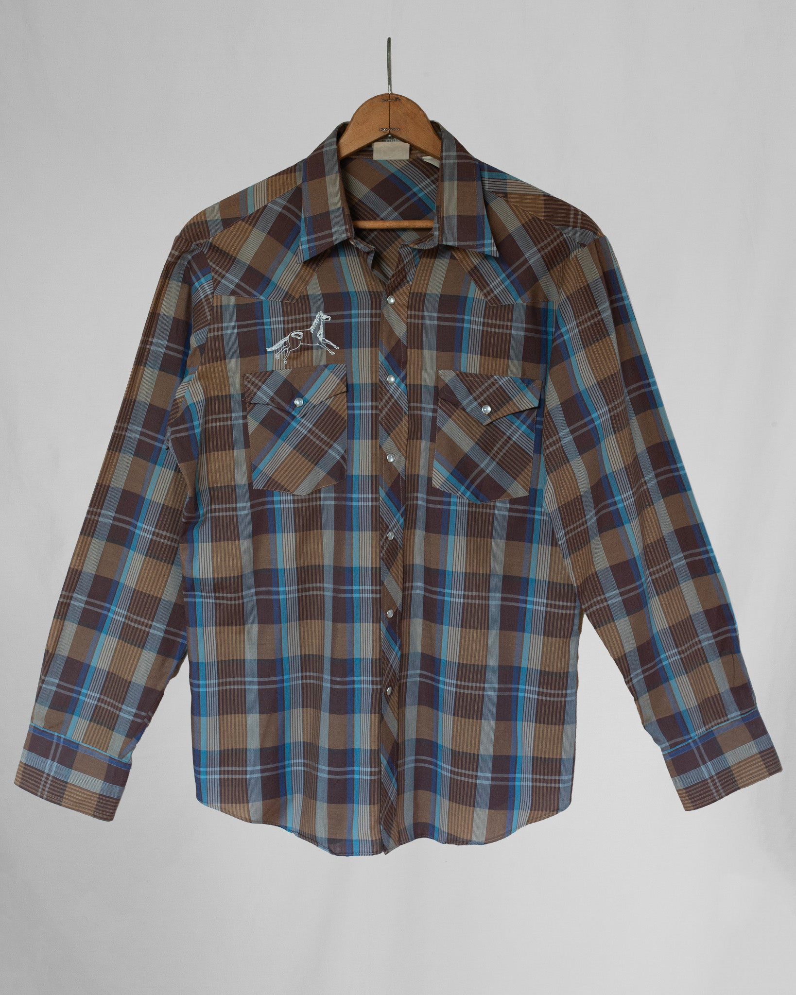 Pearl snap long sleeve with horse embroidery over chest pocket.