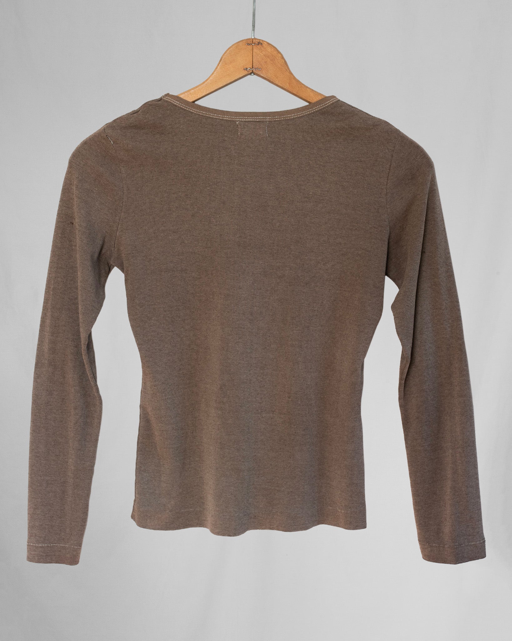 Brown long-sleeve shirt on a wooden hanger against a gray background