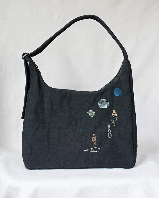 Black shoulder bag with seashell embroideries.