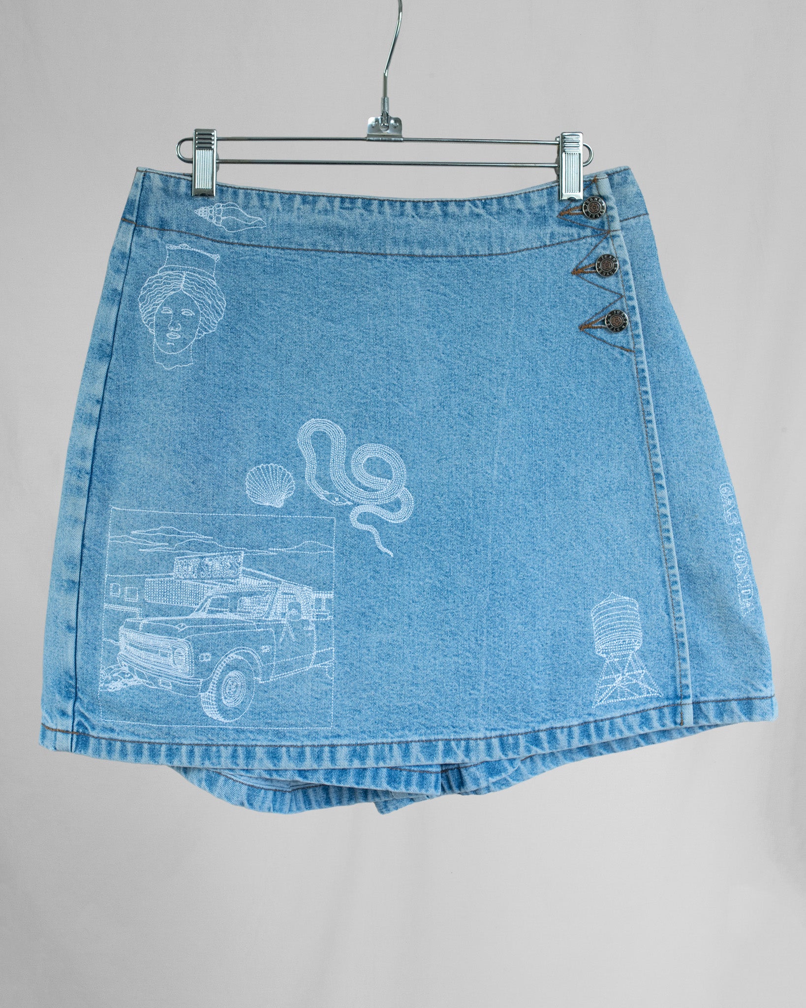 Blue denim skort with white graphics on a gray background
