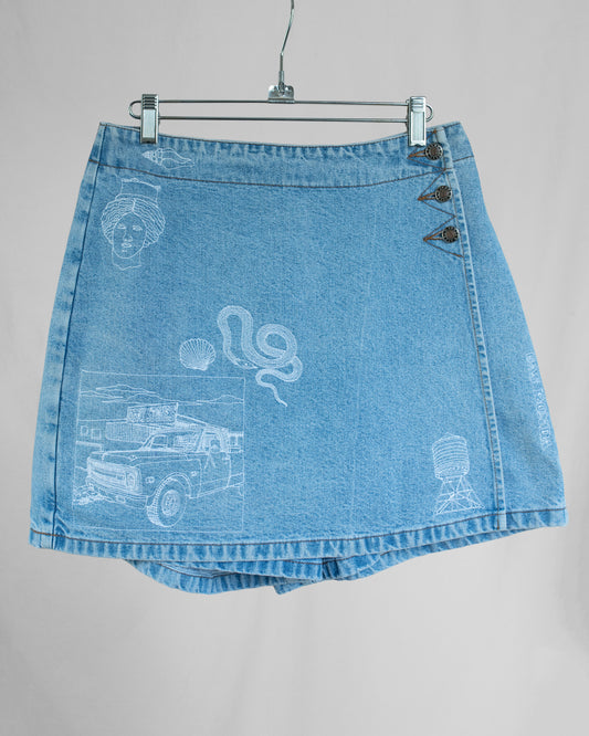 Blue denim skort with white graphics on a gray background