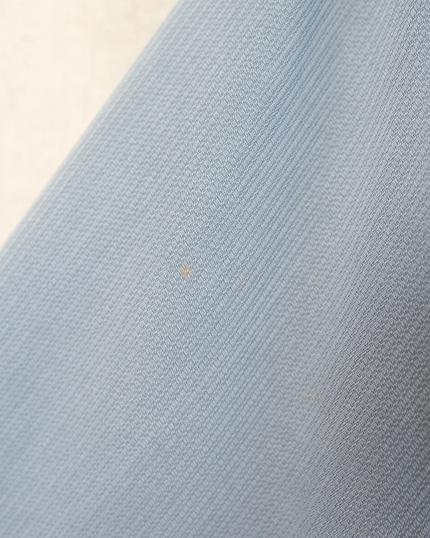 Close-up of textured light blue fabric with a neutral background