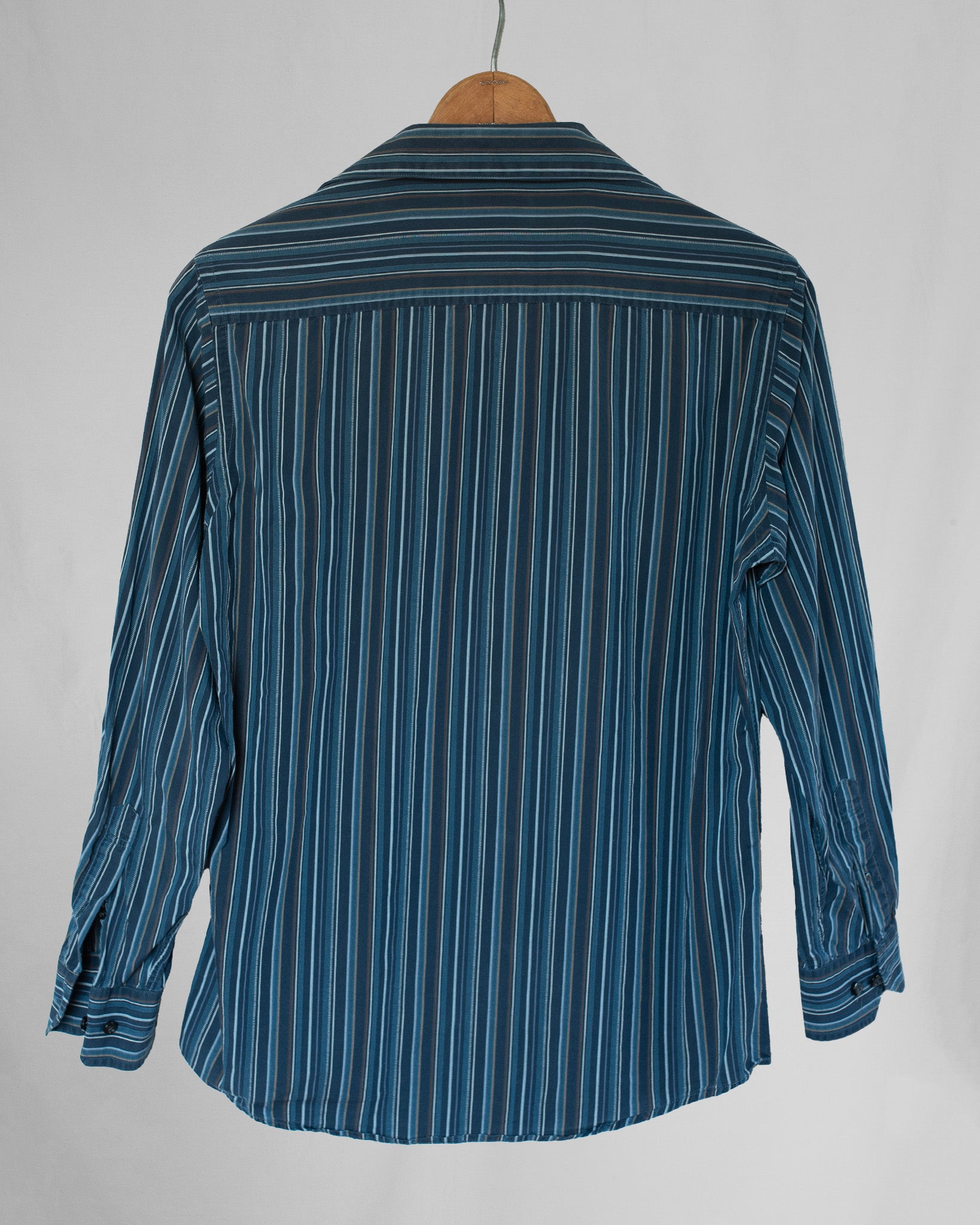 Blue striped shirt on a hanger against a gray background