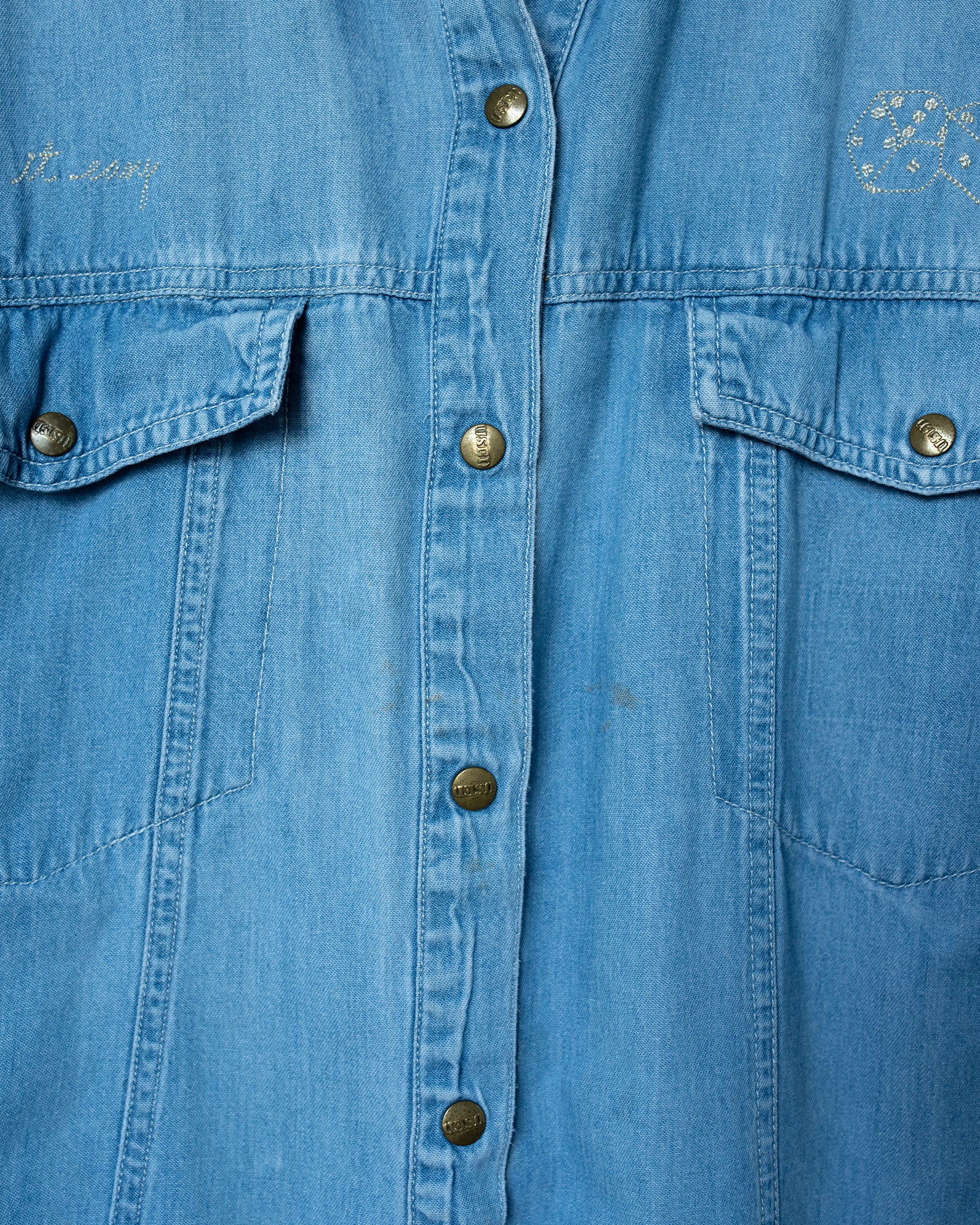 Close-up of a blue denim shirt with buttons 
