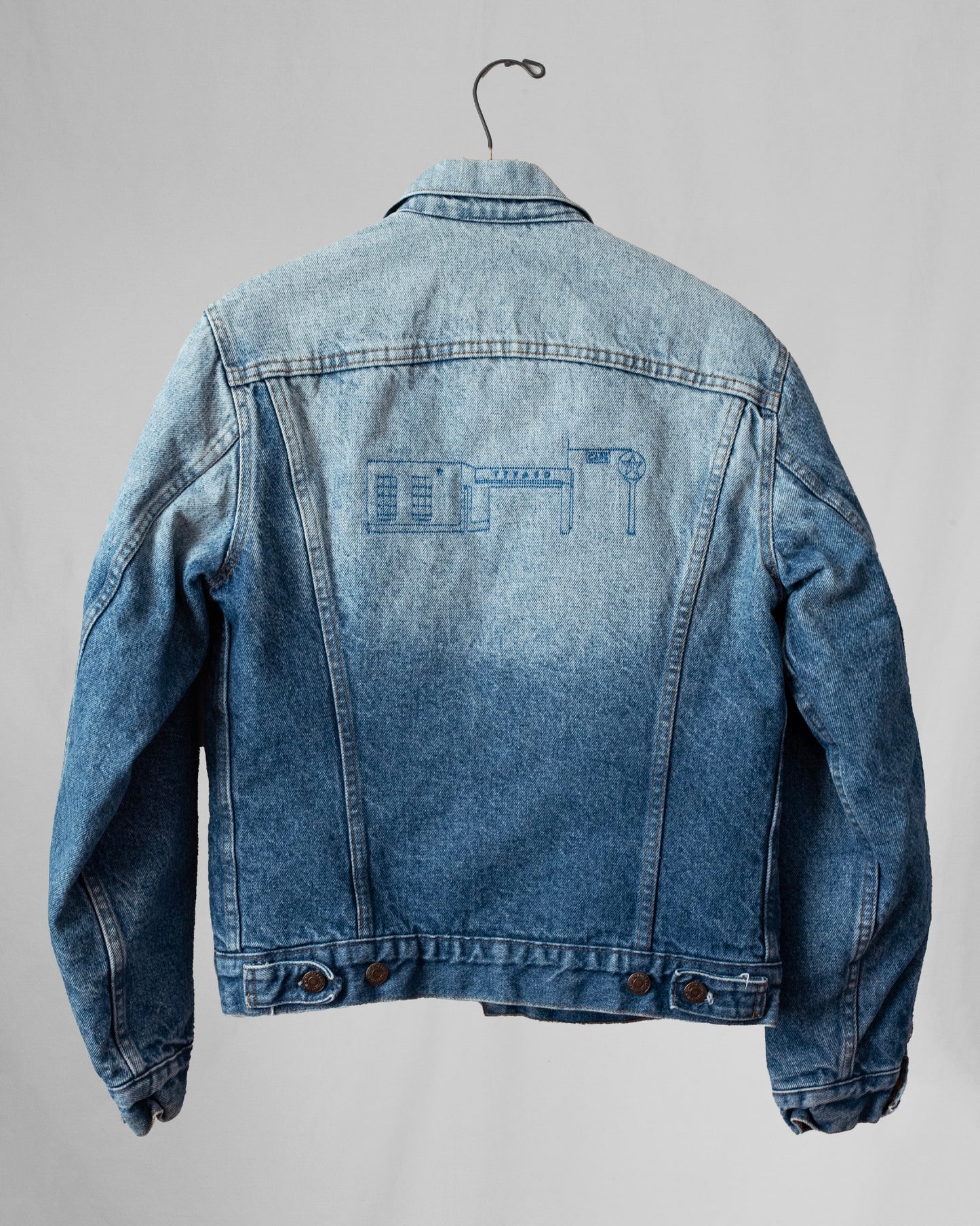 Blue denim jacket with embroidery on a gray background
