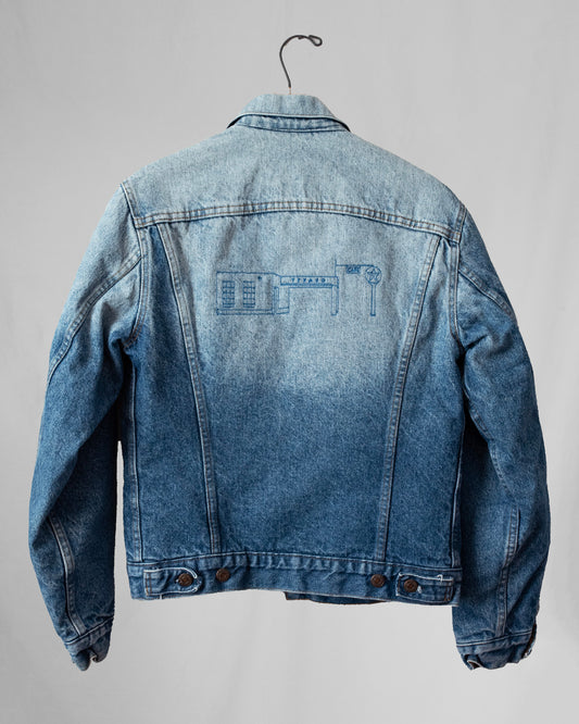 Blue denim jacket with embroidery on a gray background