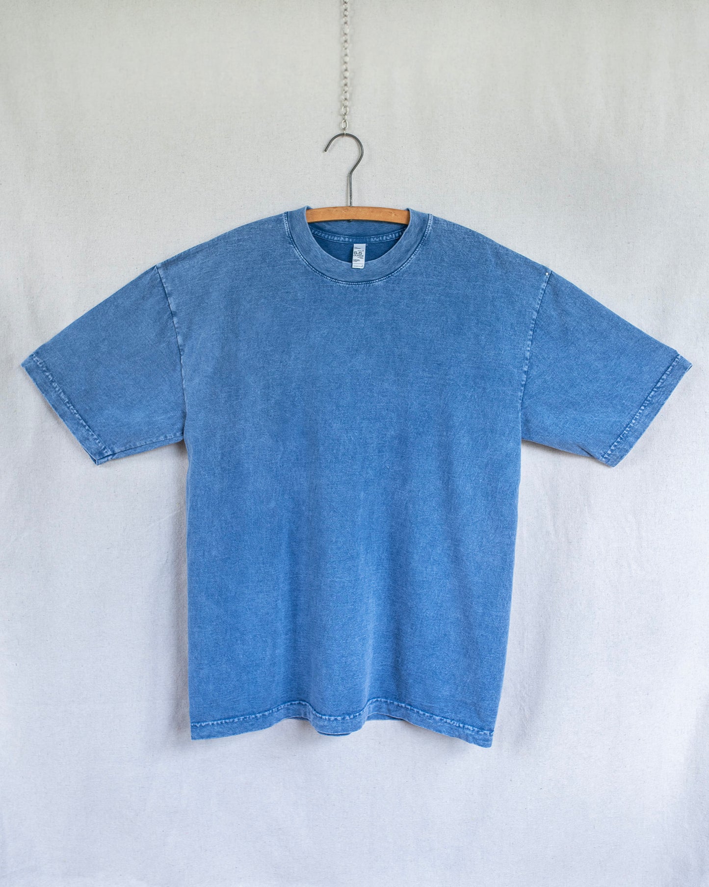 Blue t-shirt on a hanger against a white background