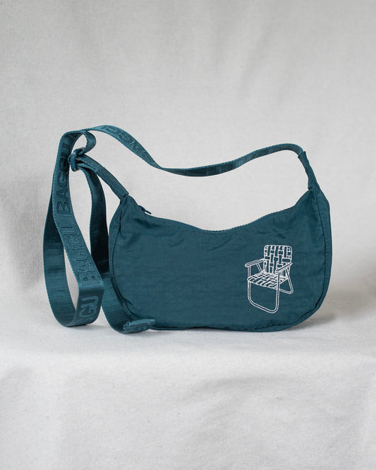 Deep sea colored cross body bag with a lawn chair embroidery